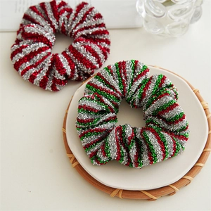 Close-up of sparkling Christmas scrunchies with metallic red and green festive knit patterns
