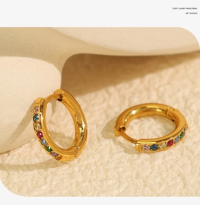Detailed macro view of rainbow cubic zirconia stones set in a gold-plated stainless steel earring