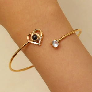 Gros plan du bracelet cœur doré avec pierre de projection et incrustation zircon