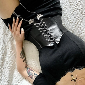 Detail of black leather corset belt featuring silver metal chains and butterfly accents