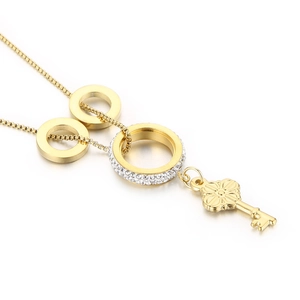 Gold layered necklace with key pendant and rhinestone circles in a minimalist fashion style