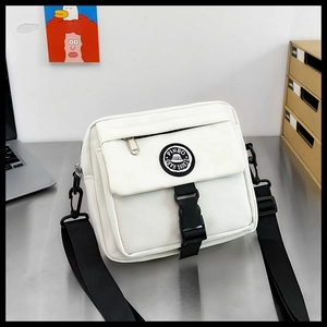Detailed close-up of white canvas messenger bag with black buckle and adjustable strap