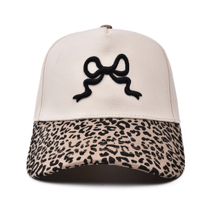 Dettaglio del fiocco nero ricamato 3D e visiera leopardata sul cappellino alla moda