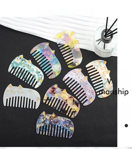 Flat lay of colorful cat-shaped acetate hair combs with marble textures and wide teeth