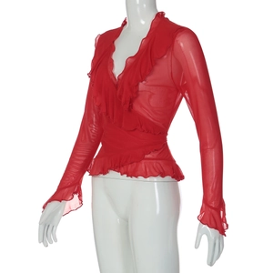 Détail du tissu en maille rouge avec volants et décolleté en V sur le haut à manches