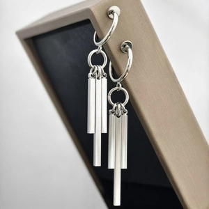 Detail of silver titanium long tassel earrings with geometric column pendants
