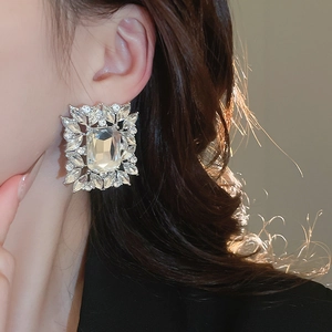 Macro shot of silver stud earrings with emerald-cut crystal and marquise stones