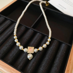 Elegant gold plated pearl necklace featuring a square pendant with pink mother-of-pearl