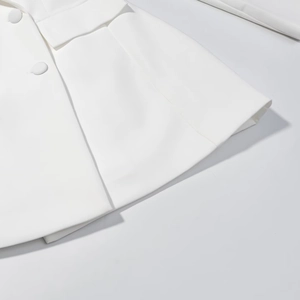 Detail of white double-breasted blazer dress with flap pockets and smooth fabric