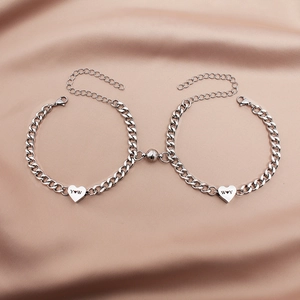 Detail of silver Cuban chain bracelets with heart charms and magnetic closure