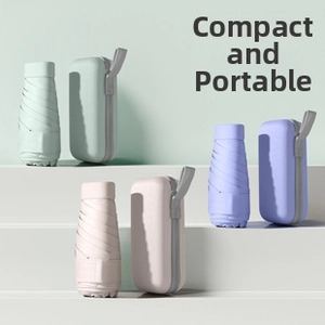 Mini capsule umbrellas in pastel colors with matching hard cases on a tiered display