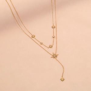 Close-up of gold Y-shaped necklace with layered star pendants and sparkling rhinestones