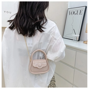 Detailed back view of a mini cream jelly crossbody bag with gold chain strap on a model