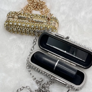 Detailed interior of rhinestone lipstick case showing built-in mirror and gold-silver finish