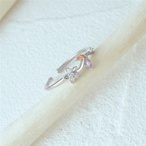 Macro shot of silver open ring with colorful flower petals and marquise cut gemstones