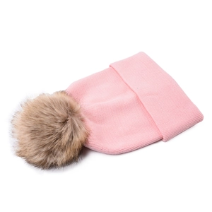 Close-up of pink knitted beanie with a large detachable brown faux fur pom pom top