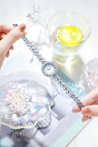 Close-up of elegant silver women's watch with crystal-encrusted leaf-shaped strap and white dial