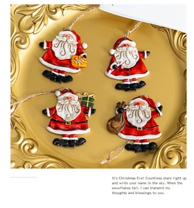 Close-up of four vintage resin Santa Claus ornaments on a gold embossed plate