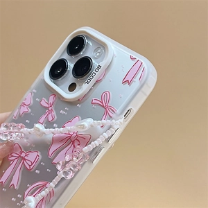 Pink bow and white polka dot clear phone case with a beaded heart-shaped charm strap