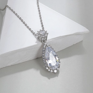 Pear cut pink crystal pendant necklace with pave diamonds on white geometric stone