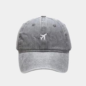 Close-up of airplane embroidery on vintage washed denim gray baseball cap fabric