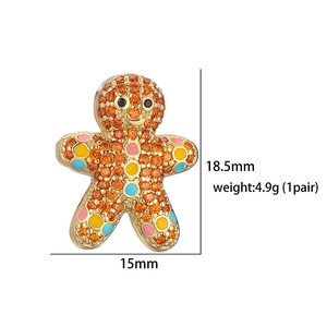 Detailed size view of gingerbread man stud earrings with orange crystals and gold base