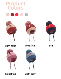 Detail showing colorful kids winter knit beanies with cute pom-poms and ear protection