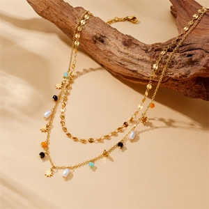 Double-layered gold chain necklace with colorful beads and star pendant on wood
