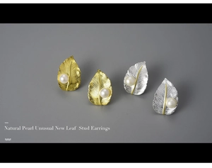 Detailed macro view of gold and silver leaf stud earrings with natural pearls