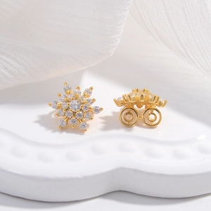 Elegant gold snowflake stud earrings with sparkling pavé crystals in a symmetrical floral design