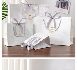 Detail of marble pattern gift bags with elegant silver ribbons and gold lettering
