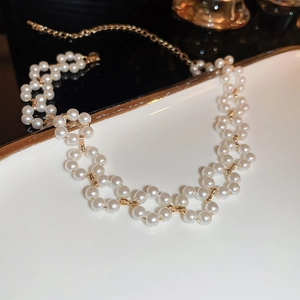 Détail du collier choker perles avec connecteurs floraux dorés et fermoir réglable