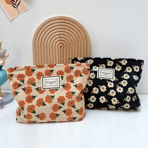 Retro floral corduroy makeup bags in beige and black with flower patterns and zipper closure
