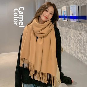 Close-up of camel solid color wool cashmere scarf with delicate fringe tassels