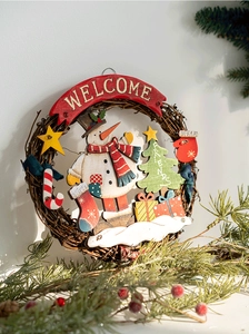 Close-up of rustic wooden Christmas welcome sign with snowman and rattan wreath details