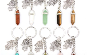Macro detail of various crystal hexagonal pillars with Hamsa Hand silver charms on keyrings
