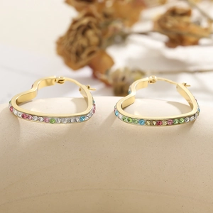 Detailed macro view of gold heart hoop earrings featuring vibrant multicolored rhinestones