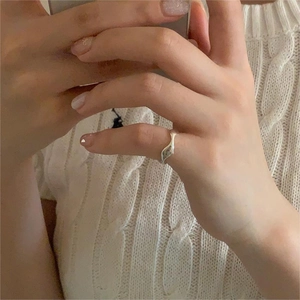 Close-up of minimalist S925 sterling silver irregular wave ring on hand with knit sweater