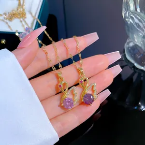 Detail of luxury swan pendant necklaces with purple stones and pavé crystals