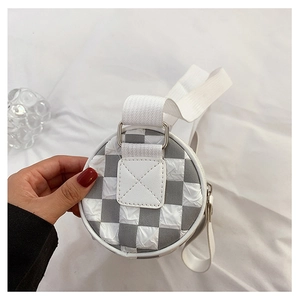 Detailed close-up of grey and white checkered cylinder bag with wide strap and silver buckle