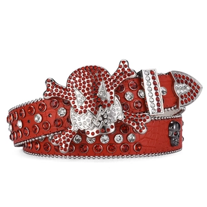 Detail of red crocodile pattern belt with large rhinestone skull and crossbones buckle