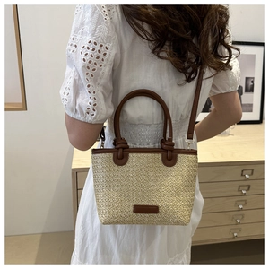 Model view of a straw tote with brown leather trim showing its scale and styling