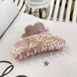 Close-up of pink heart and cloud shaped acetate hair claw clip with crystal rhinestones