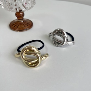 Close-up of gold and silver metallic knot hair ties with black elastic bands