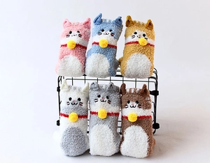 Six colorful coral fleece socks with cute cat designs and yellow bells on a black rack