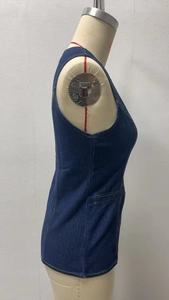 Side view of dark blue denim vest on a mannequin showing stitch detail and pocket