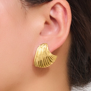 Elegant gold fan-shaped shell earrings with vertical textures worn by a female model