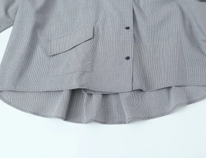 Détail de chemise en popeline à carreaux gris avec grande poche et ourlet asymétrique