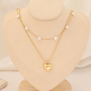 Close-up of double-layer gold necklace featuring pearl heart beads and a heart pendant