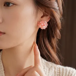 Elegant beaded cluster earrings with pink frosted beads and crystals on a model